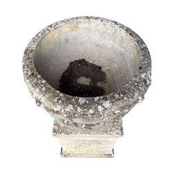 Pair of quality Neoclassical design Haddonstone cast stone garden urns, the globular  body decorated with relief foliate festoons and fruiting motifs, over a fluted socle, the rectangular pedestals with relief foliate wreaths and ribbon garlands