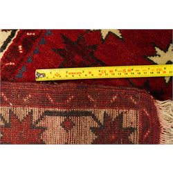 Caucasian Kazak hand-knotted rug, madder red ground with three large stepped geometric medallions in dark blue, ivory and red, surrounded by stylised star and flowerhead motifs, enclosed by ivory border with repeating eight-pointed stars, fringed ends