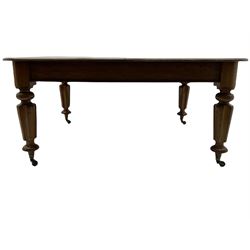 Victorian mahogany dining table, the rectangular top with rounded corners, on turned and lobed supports, brass and ceramic castors