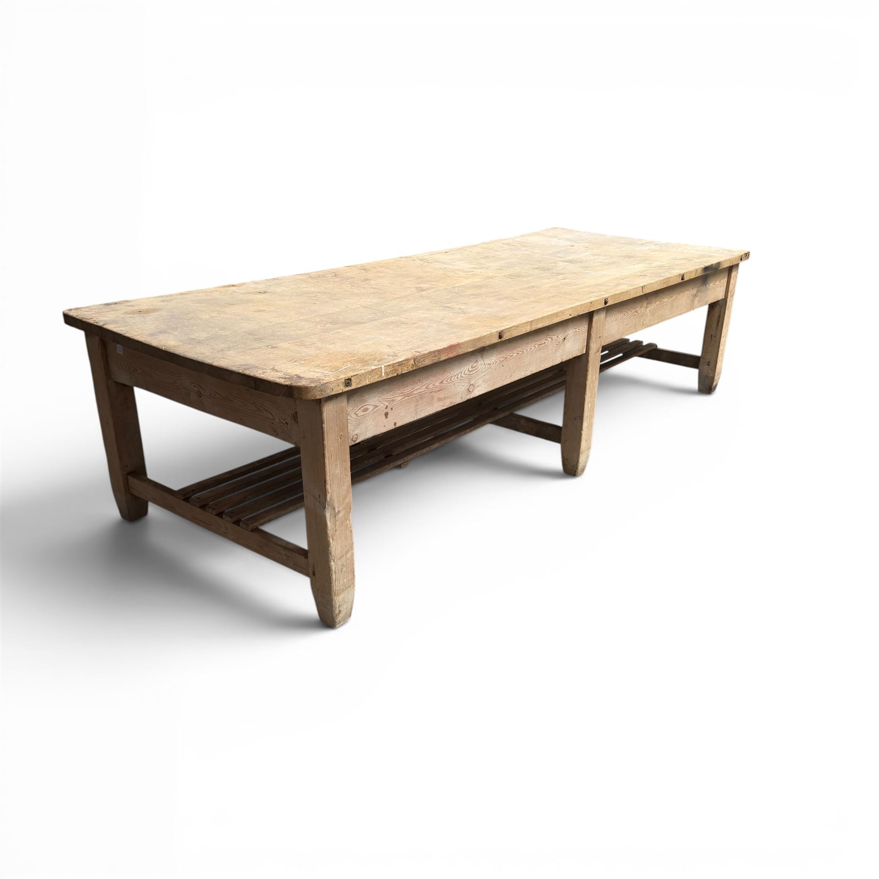 Large early/mid-20th century pine table or work bench, rectangular six plank top on eight tapering supports joined by slatted undertier