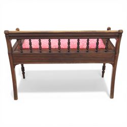 Early 20th century mahogany hall bench, spindle turned back with shaped top rail and open arms terminating in ball finials, upholstered seat within a fluted frieze, raised on turned tapering supports