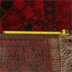 Turkmen Bokhara carpet, with a deep red field and repeating rows of black gul motifs, within multiple geometric borders