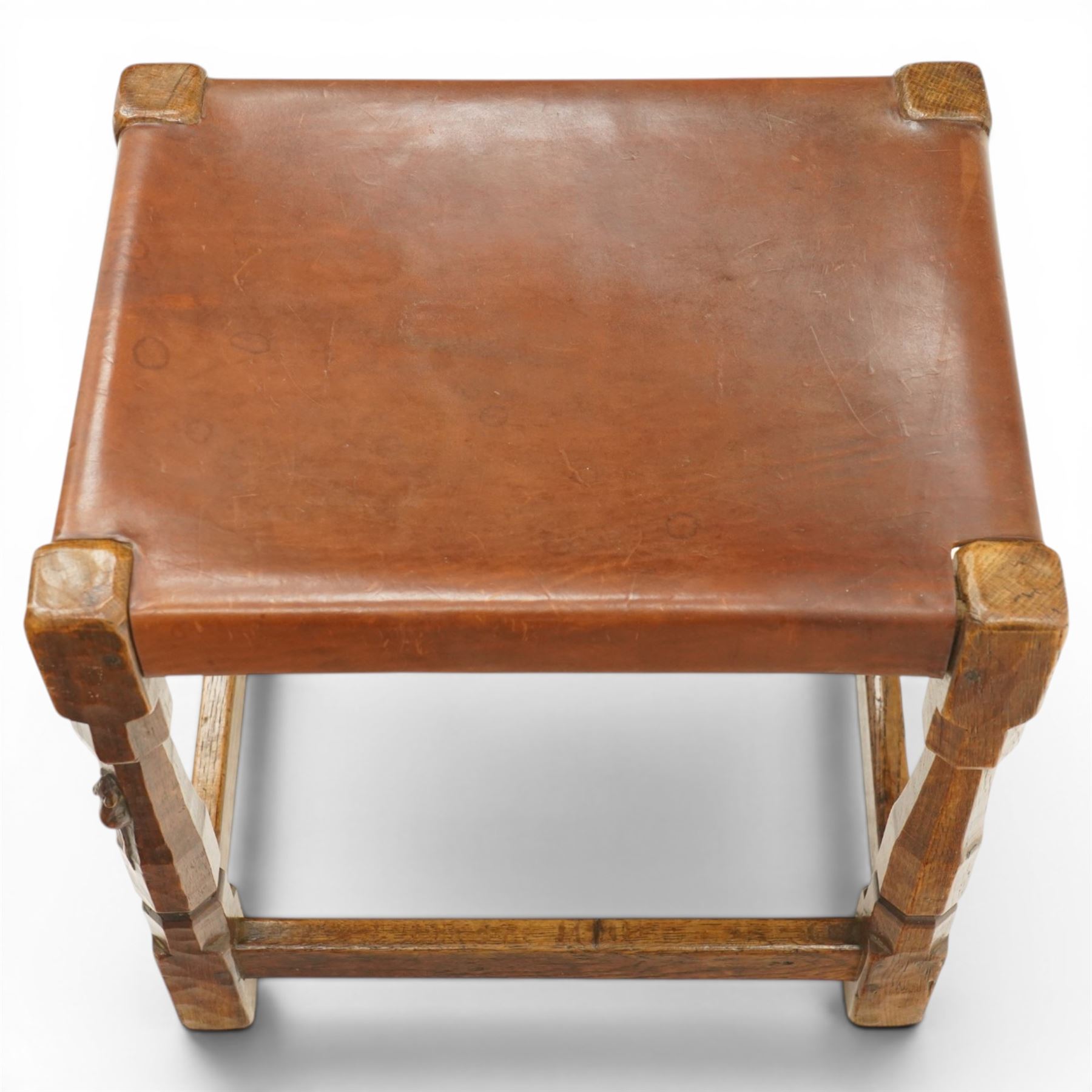 Mouseman - 1940s dark oak dressing table stool, the rectangular top with deep-tan leather seat, raised on octagonal supports united by box stretcher, with carved mouse signature, by the workshop of Robert Thompson of Kilburn