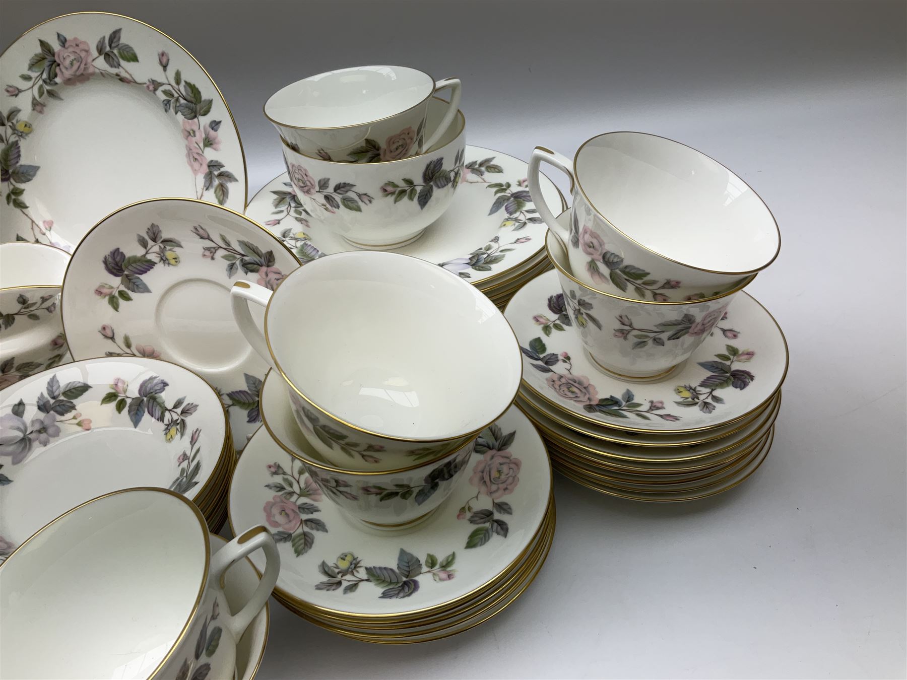 Royal Worcester June Garland pattern tea and dinner wares, comprising thirteen dinner plates, twelve dessert plates, twelve side plates, six twin handled soup bowls and six saucers, six small bowls, sauce boat and stand, thirteen teacups and fifteen saucers, open sucrier, and milk jug