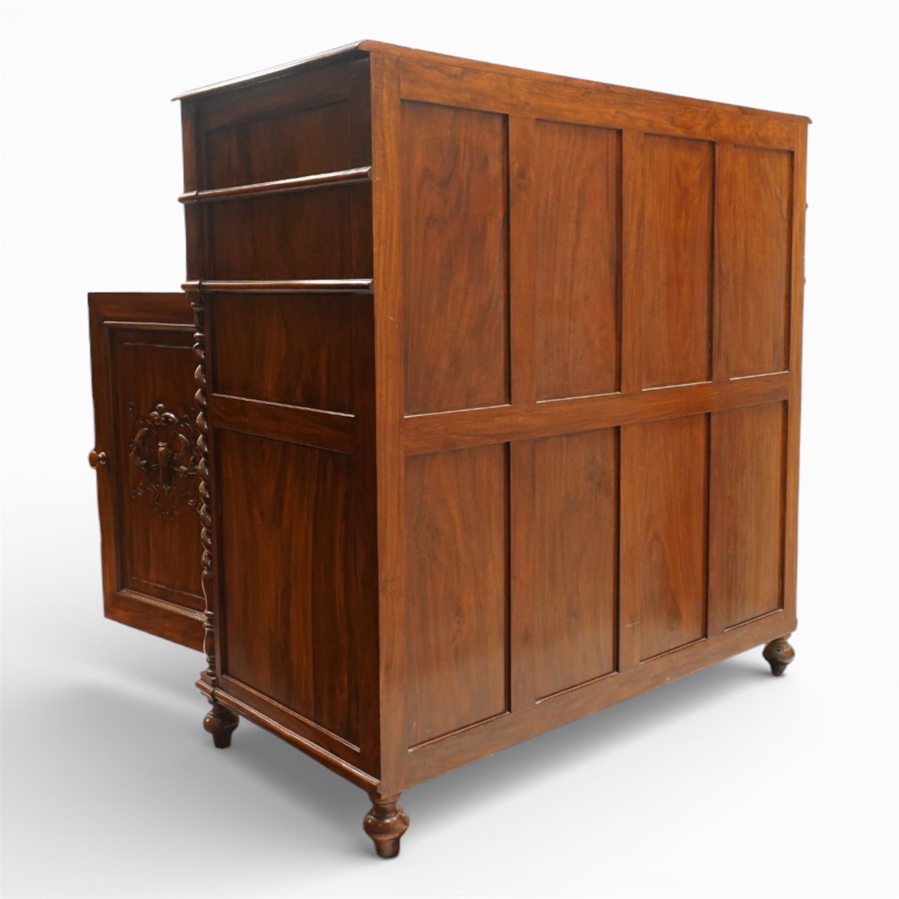 Victorian design rosewood side cabinet, the rectangular moulded top above four frieze drawers with turned wooden knob handles, over twin cupboard doors carved with foliate panels, flanked by barley twist uprights, upon turned bun feet