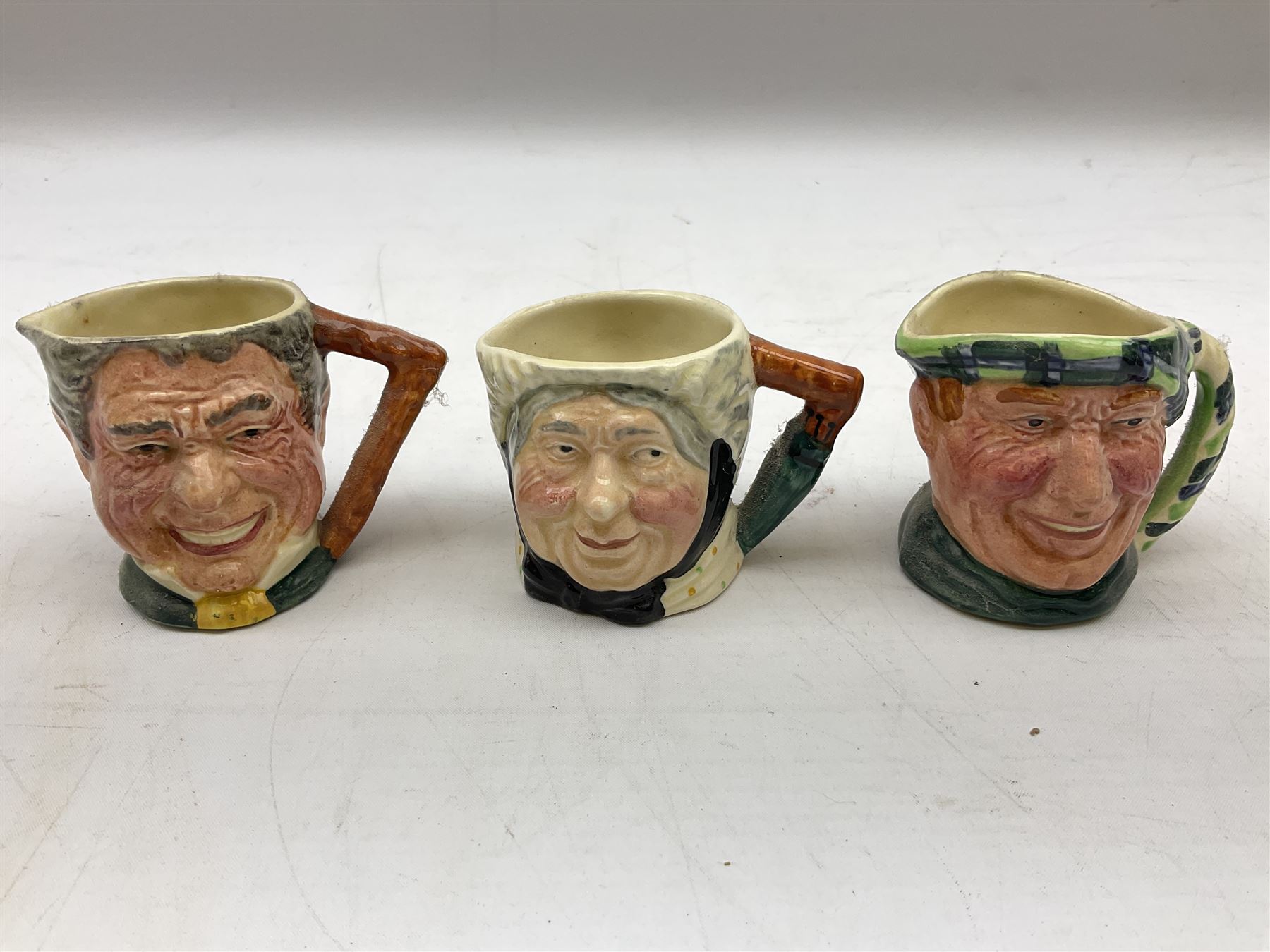 John Beswick figure of a seated piglet, Beswick Beatrix Potter Mrs Rabbit and Peter figure, and quantity of Sandland Character Ware jugs