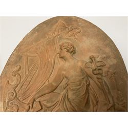 Pair of 19th century classical terracotta relief wall plaques depicting the goddess Hygeia and another goddess, seated holding an ewer, each of oval form, indistinctly signed, each stamped Ferreira verso, H42cm, W30cm