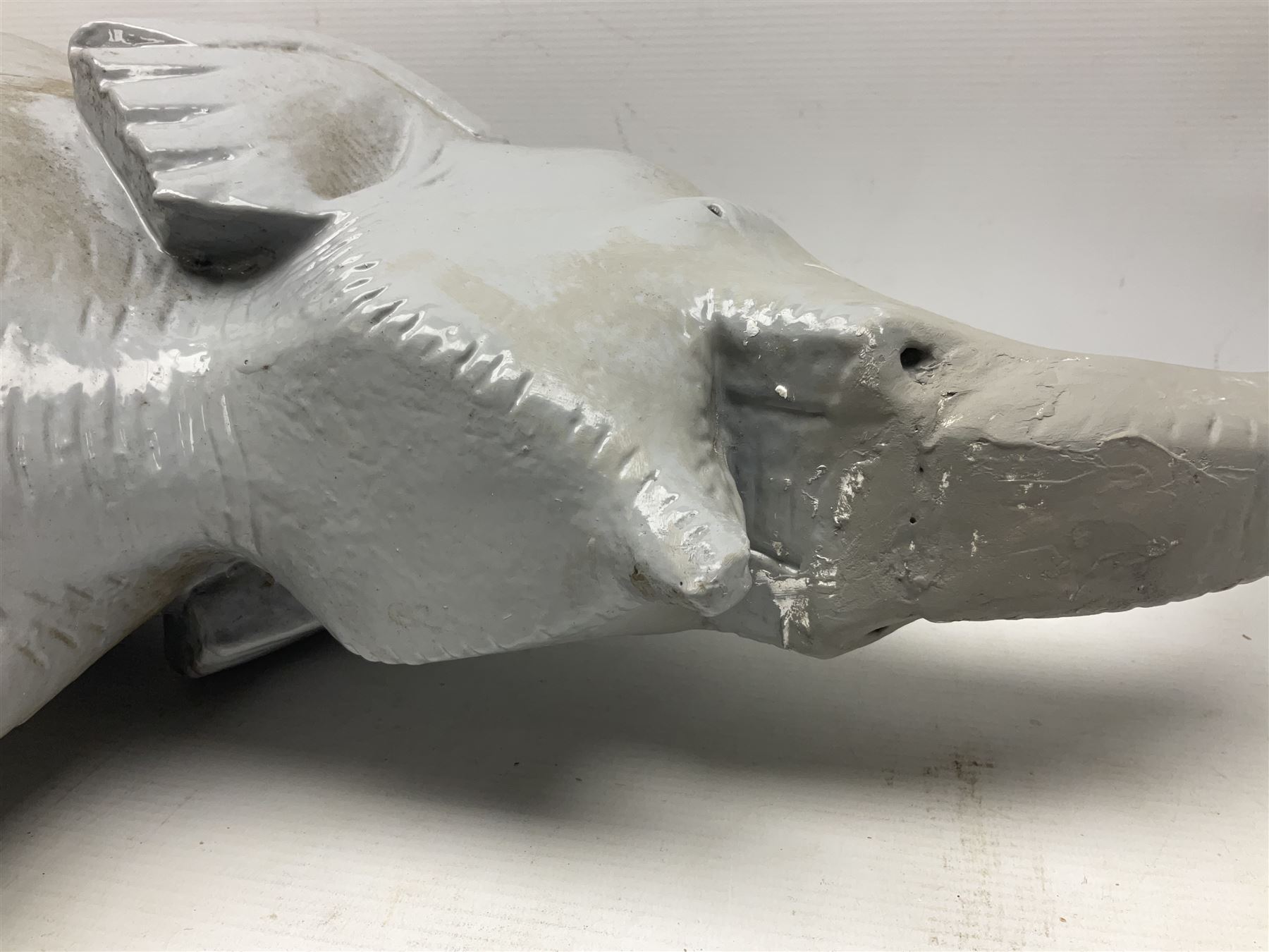 Composite figure of an elephant, painted grey, upon white base, L45cm H65cm