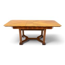Art Deco walnut extending dining table, book-matched veneered shaped top, raised on cluste...