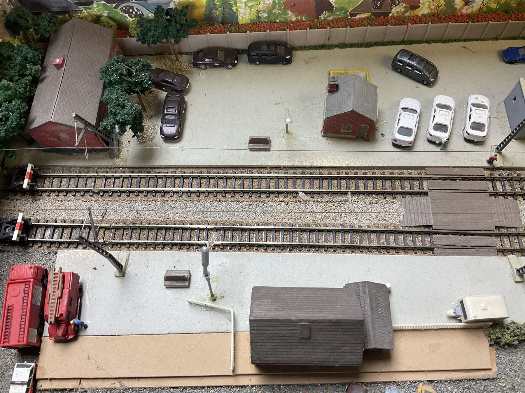 'Z' gauge continental scenic layout with folding legs, various loops of track and sidings with overhead cables, buildings including water tower, tunnels, roads with motor vehicles and figures, trees, haven with boats, backdrop diving wall hiding control units 150 x 50cm