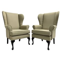  Pair of Queen Anne design wingback armchairs, traditional shape with rolled arms, upholstered in fan patterned fabric, raised on ebonised cabriole supports