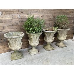 Set of four Victorian design cast stone Grecian urns, tapering form cast with figures and handles, square plinth bases