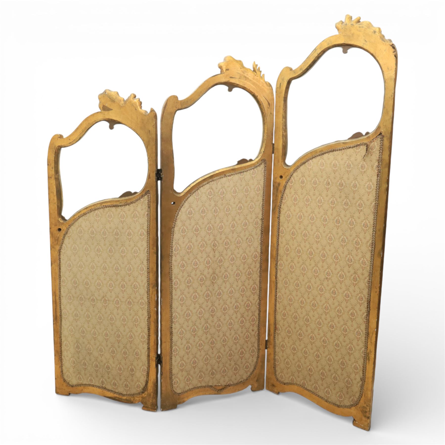 Rococo style giltwood three-panel dressing screen, each panel with shaped and scroll carved frame decorated with shell and foliate motifs, the upper sections glazed, the lower sections upholstered in patterned fabric, hinged to form a folding screen
