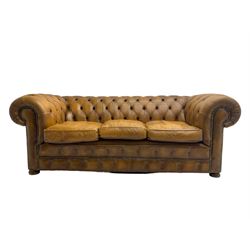 Chesterfield three seat sofa, upholstered in buttoned tan leather with studded detail, on turned feet