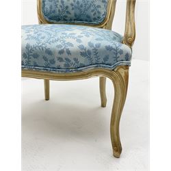 Pair French style bedroom armchairs, moulded frames and scroll carved arms, serpentine seat with cabriole supports, upholstered in a light blue foliate pattern fabric, sprung seat