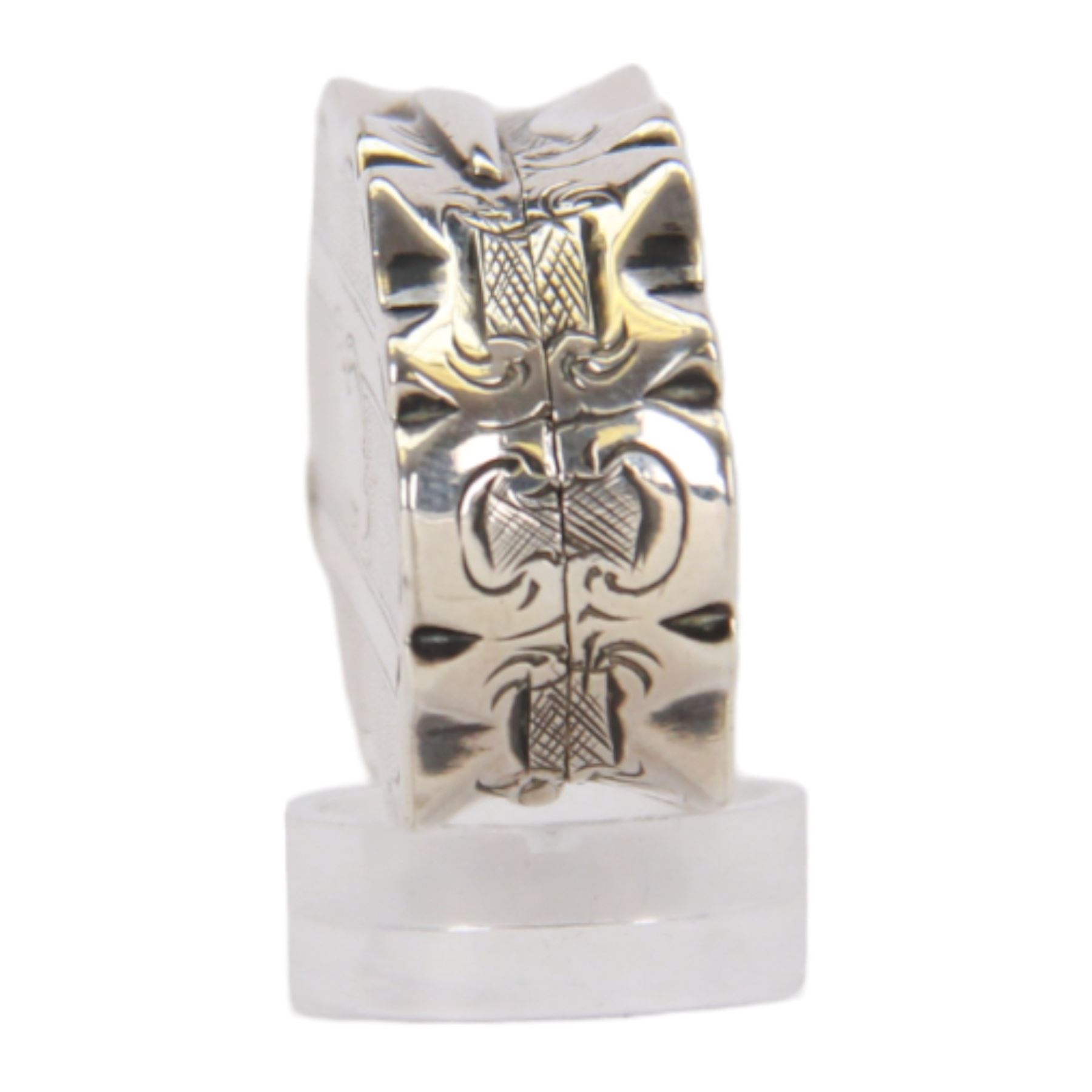 Victorian silver vinaigrette, of oval form with shaped edge, decorated throughout with engine turned bands, the hinged cover with vacant C scroll panel opening to reveal a foliate pierced grille and gilt interior, hallmarked George Unite, Birmingham 1857, L3.5cm