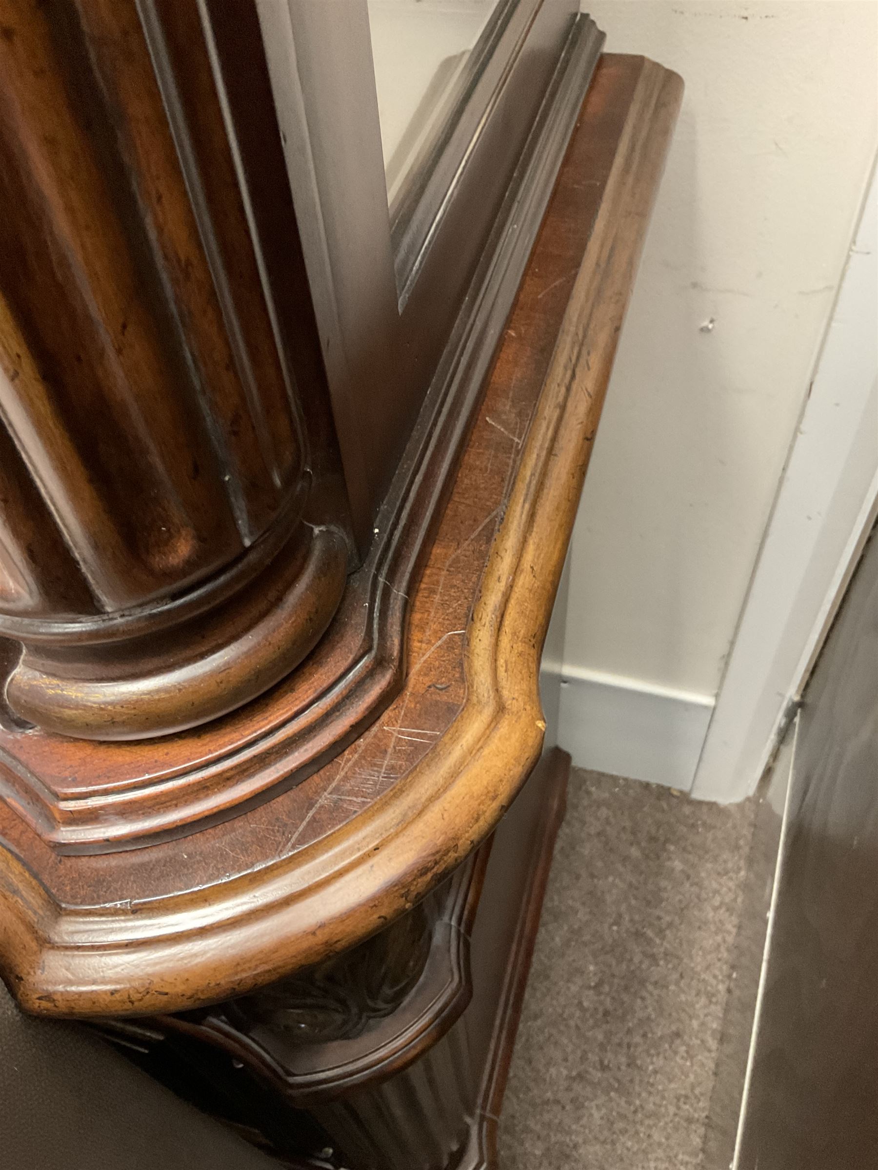 Kevin Charles American walnut display cabinet, illuminated interior, shell carved pediment above four bevel edge doors enclosing six glazed shelves above one central long drawer flanked by two short drawers, above three cupboards, carved bracket supports 