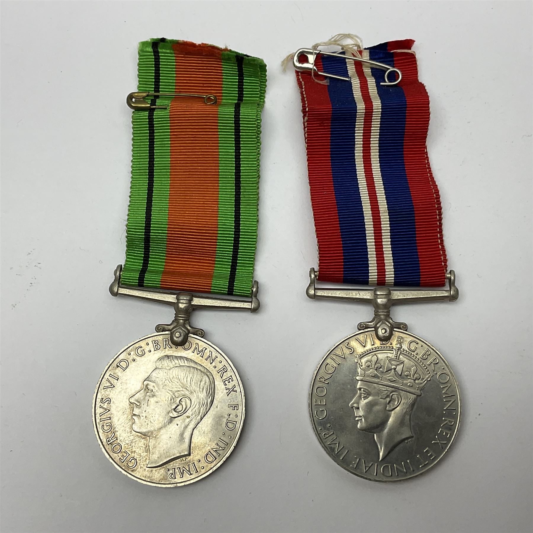 WW1 pair of medals awarded to 151761 Gnr. S. Loten R.A. with ribbons; four WW2 medals with ribbons; and small quantity of cap badges, medallions etc