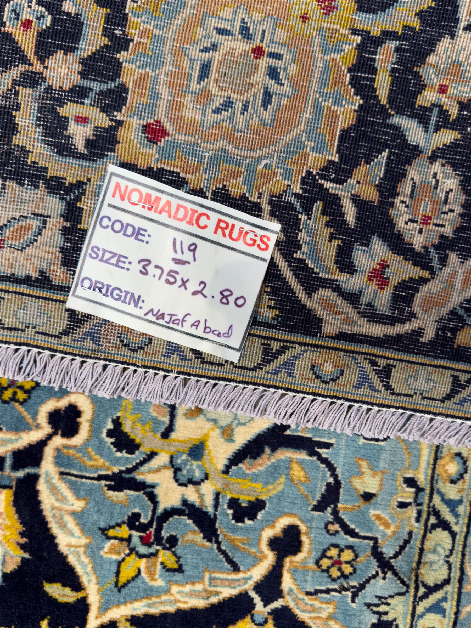 Central Persian Kashan hand-knotted carpet, the navy field with central medallion in pale blue and gold tones, surrounded by spiralling arabesques and palmettes, framed by quarter spandrels and a wide border of stylised lotus and rosette motifs between floral guard stripes, from the region of Kashan