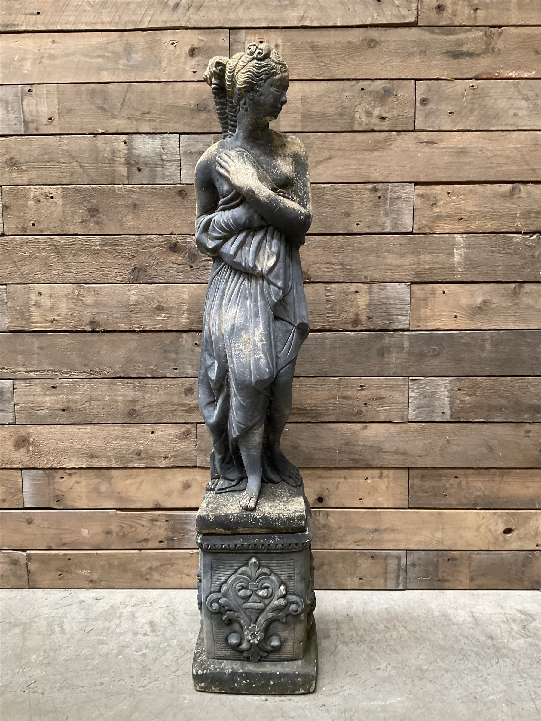 Cast stone weathered garden statue of Venus on pedestal
