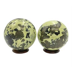 Pair of green serpentine spheres, upon carved stone bases, D6cm