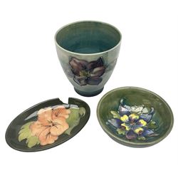 Moorcroft vase of tapering form decorated in the Clematis pattern, upon merging blue green ground, together with a small Green Columbine pattern footed bowl, and Hibiscus pattern dish of oval form, all with impressed marks beneath, tallest H9cm (3)