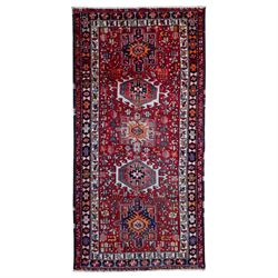 North West Persian Heriz rug, red field with a stepped medallion design flanked by stylise...