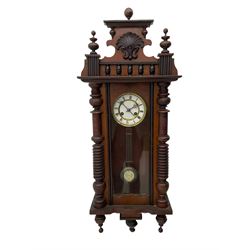 A  German spring driven wall clock c1900 within a glazed case with side panels and a full-length arched door and ornately carved pediment, turned finials and original pendant finials, with a 5' two-piece white enamel dial with roman numerals, minute markers and pierced steel gothic hands, with a visible gridiron pendulum with an R/A inscribed pressed brass bob, eight-day movement striking the hours and half hours on a coiled gong.  




