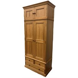 Solid pine double wardrobe, fitted with top box, enclosed by panelled doors, two short and one long drawer, on plinth base 