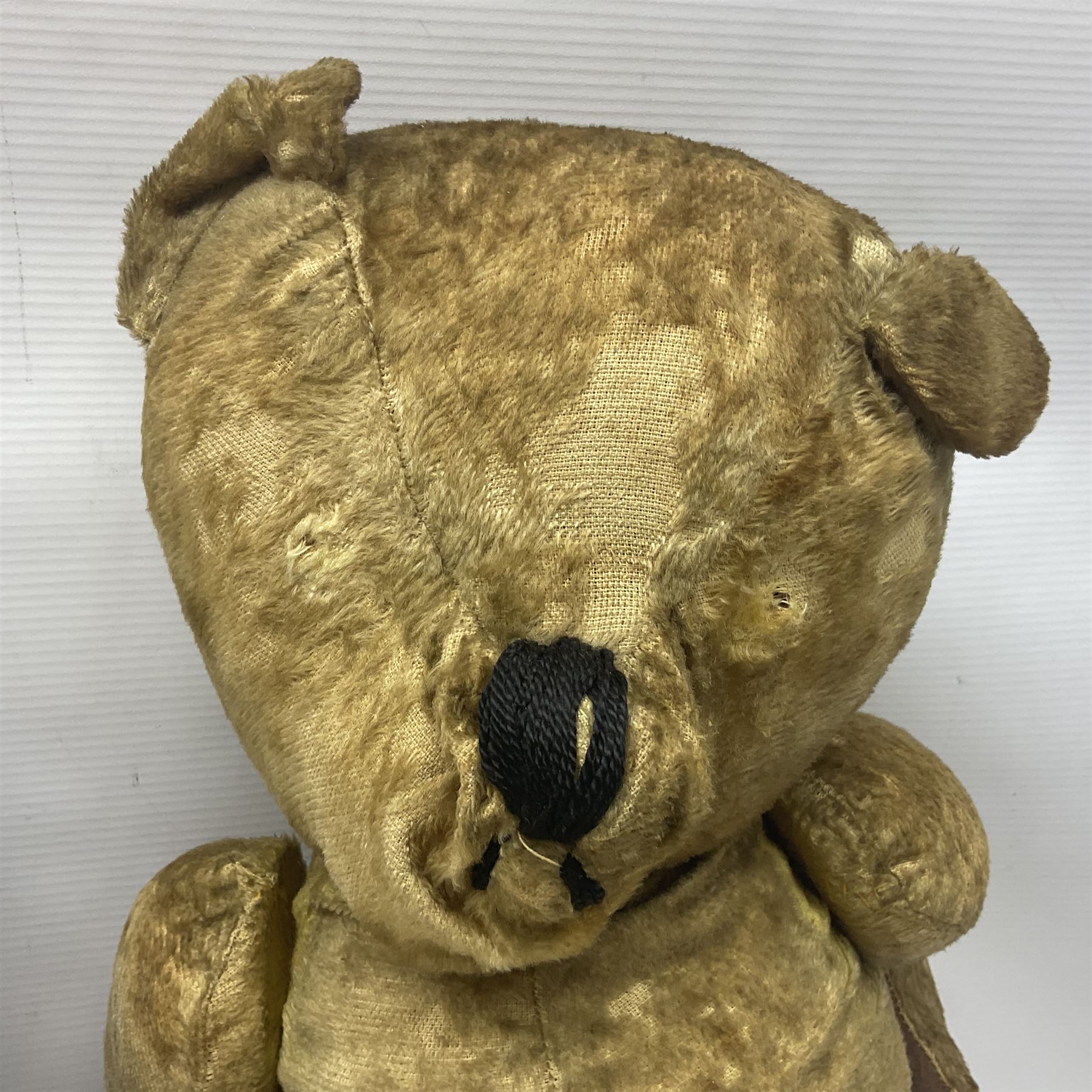 Mid-20th century woodwool filled teddy bear; and porcelain doll dressed as a WW2 evacuee
