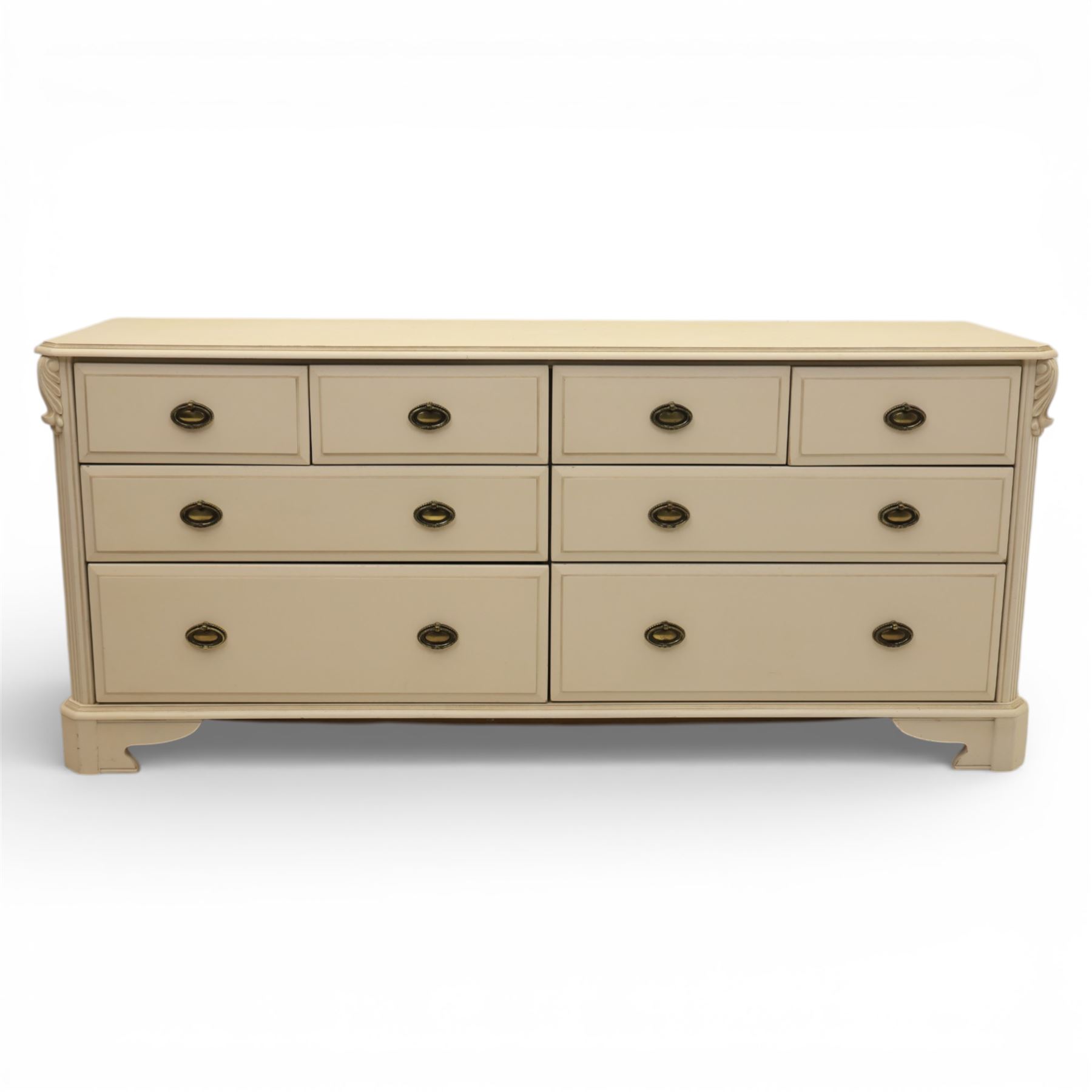 Contemporary French design white painted bedroom suite retailed by Barkers of Northallerton, comprising wide chest fitted with four short and four long drawers with oval brass handles (H 70cm, W 159cm, D 46cm), pair of bedside chests each fitted with three drawers (H 62cm, W 40cm, D 46cm), dressing table fitted with four short drawers and central kneehole with shaped apron (H 79cm, W 131cm, D 46cm) with matching framed wall mounted mirror (H 100cm, W 113cm), and full length standing mirror (H 175cm, W 73cm)