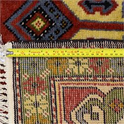 Caucasian Kazak design wool rug, cream field with three large geometric medallions and stylised hooked motifs, enclosed by polychrome reciprocal border and green floral guard stripes
