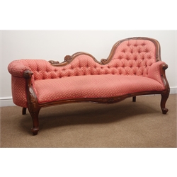  Victorian style walnut framed chaise longue, floral carved shaped cresting rail, upholstered in a deep buttoned red fabric, acanthus carved supports, L190cm  