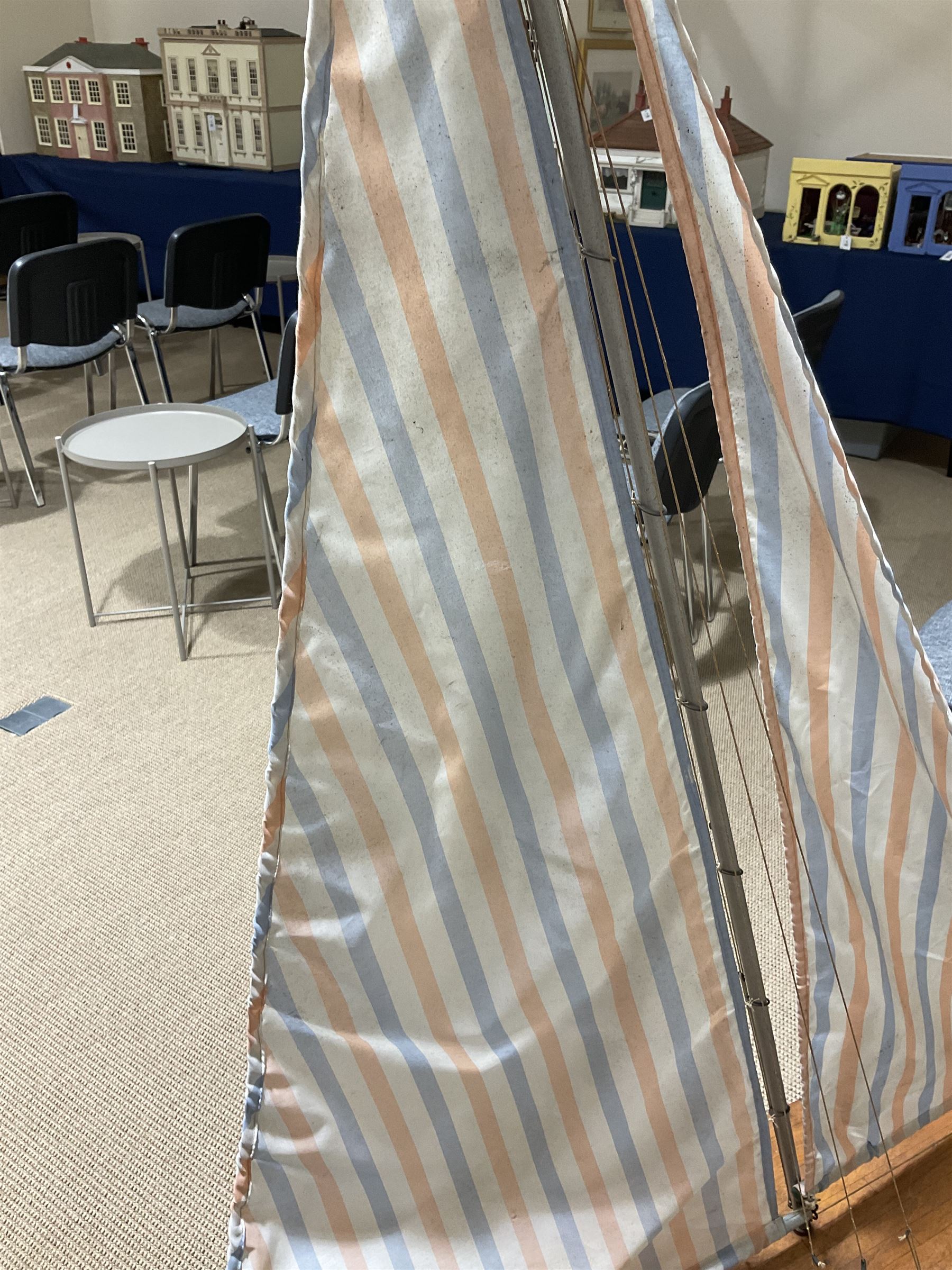 Large pond yacht with simulated planked mahogany deck, mahogany hull, wooden keel and stern fin and tubular aluminium mast with two sails; on wooden stand L131cm H on stand 177cm