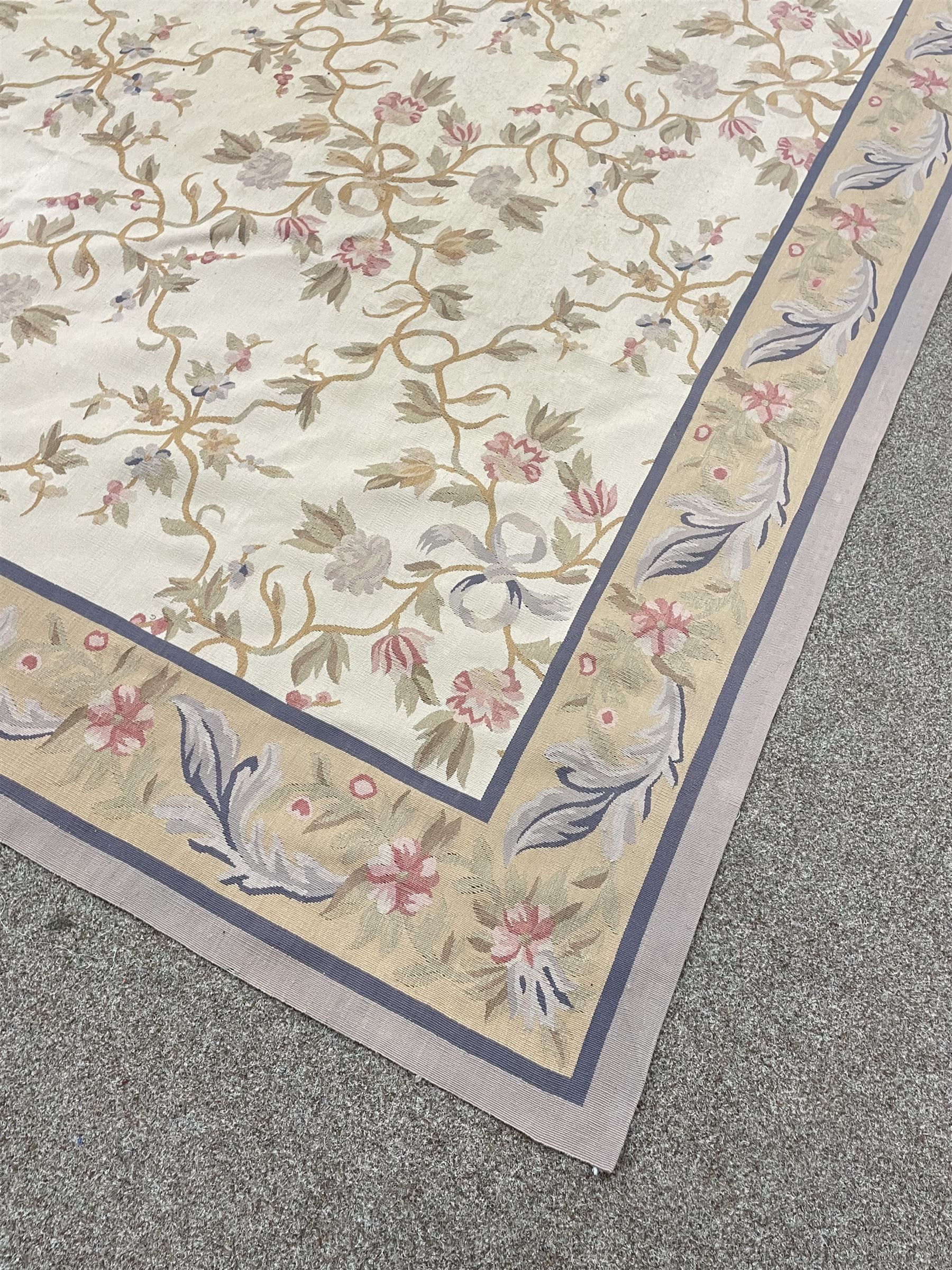 French style Aubusson rug, the pale ground field decorated with interlacing foliage and flower heads, repeating border 