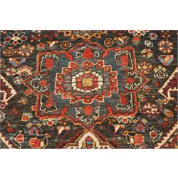 Antique Persian Qashqai dark indigo ground tribal rug, the busy field decorated with a geometric triple pole medallion surrounded by numerous stylised plant motifs with contrasting cyan spandrels, the multiple guard bands woven with stylised palmettes and foliage