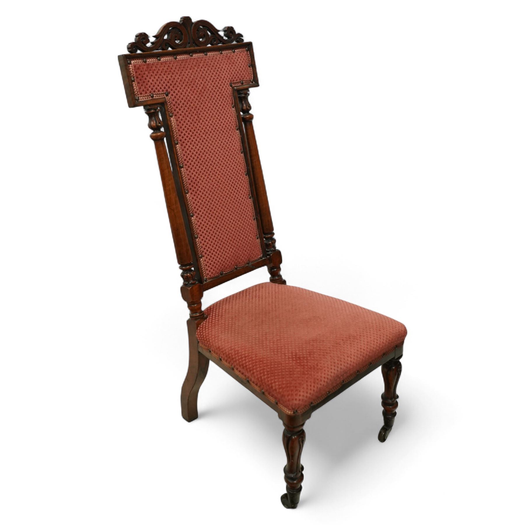 Victorian walnut high back hall chair, with pierced and scrolled crested rail above a rectangular back and seat upholstered in plush cerise fabric, flanked by tulip carved and turned uprights raised on turned and tapered front legs  