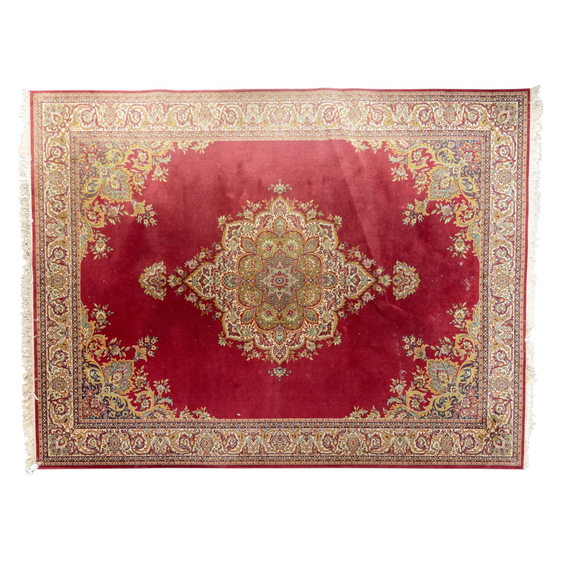 Kashan design carpet, crimson field with central medallion and scrolling floral sprays, cream and polychrome palmette and scrolling vine borders  