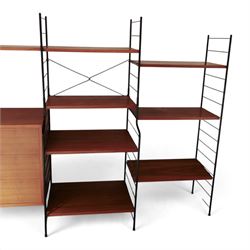 WHB - 'Ladderax' 1960s German modular shelving wall unit, comprising two teak cabinets with white doors, a further fall front teak cabinet with white front, a drawer section with three drawers with recessed handles, multiple shelving sections, raised on metal ladder frames, with further spare sections

Cabinet units: H 47cm, D 36cm, W 71cm
Fall front unit: H 40cm, D 26cm, W 71cm
Shelve widths: 50cm, 71cm 
Shelve depths: 26cm, 36cm