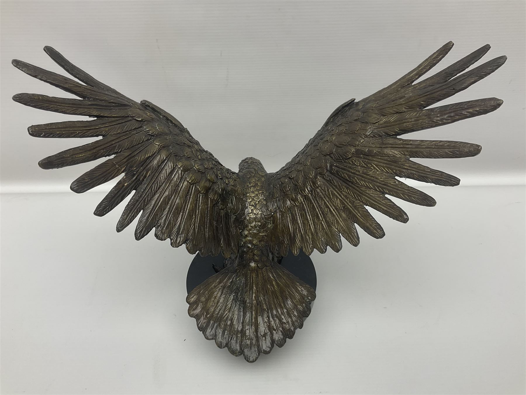Bronze eagle, modelled in a standing position with wings spread, raised on a black veined marble circular plinth base, H29cm