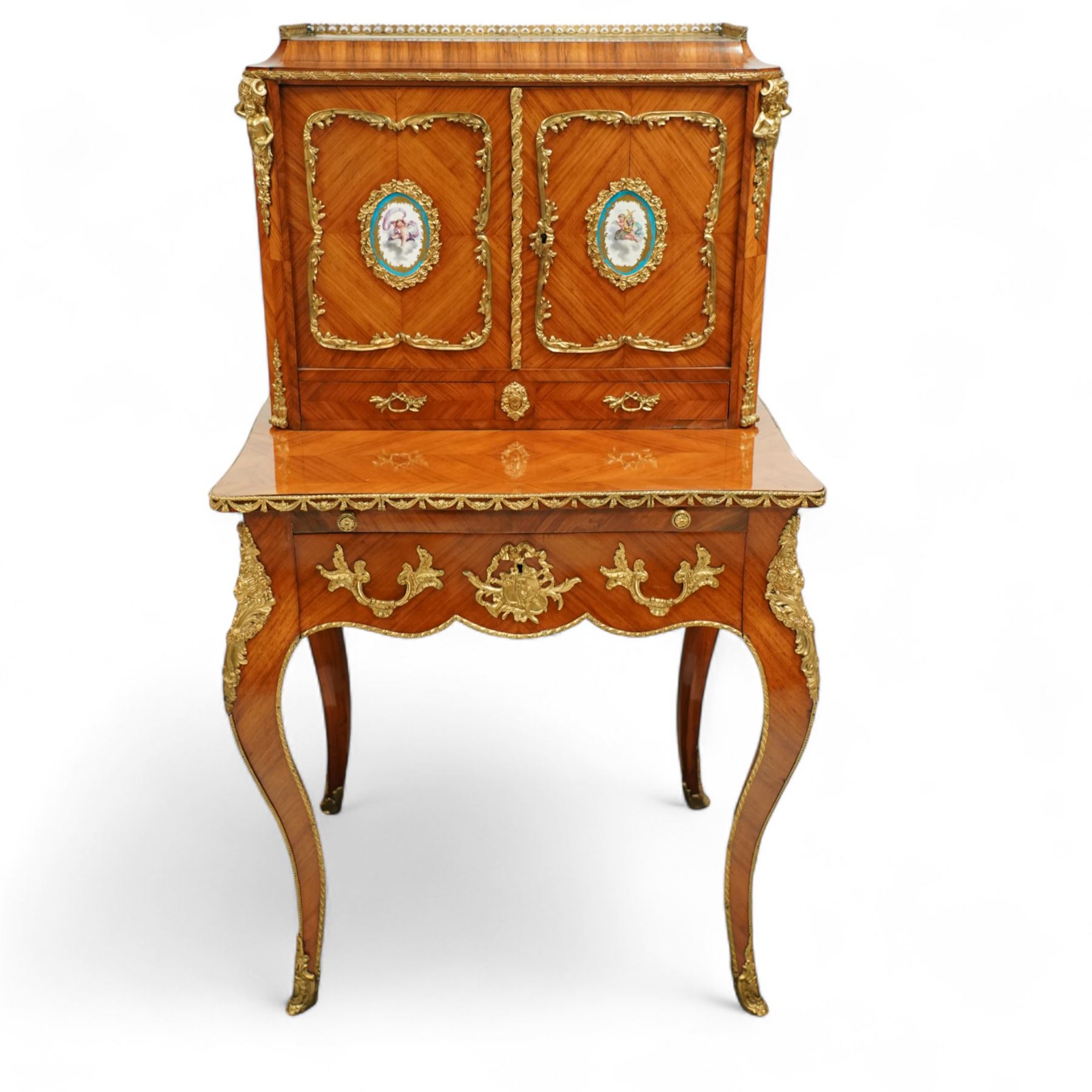 Late 19th century French Louis XV style kingwood and ormolu mounted bonheur du jour, the upper section with a pierced three-quarter gallery over a pair of cupboard doors inset with Sèvres-style porcelain portrait plaques, enclosing a shelved interior over two short drawers, the serpentine top and apron richly mounted with gilt-bronze foliate and scroll motifs, single frieze drawer below on cabriole supports with acanthus cast sabots