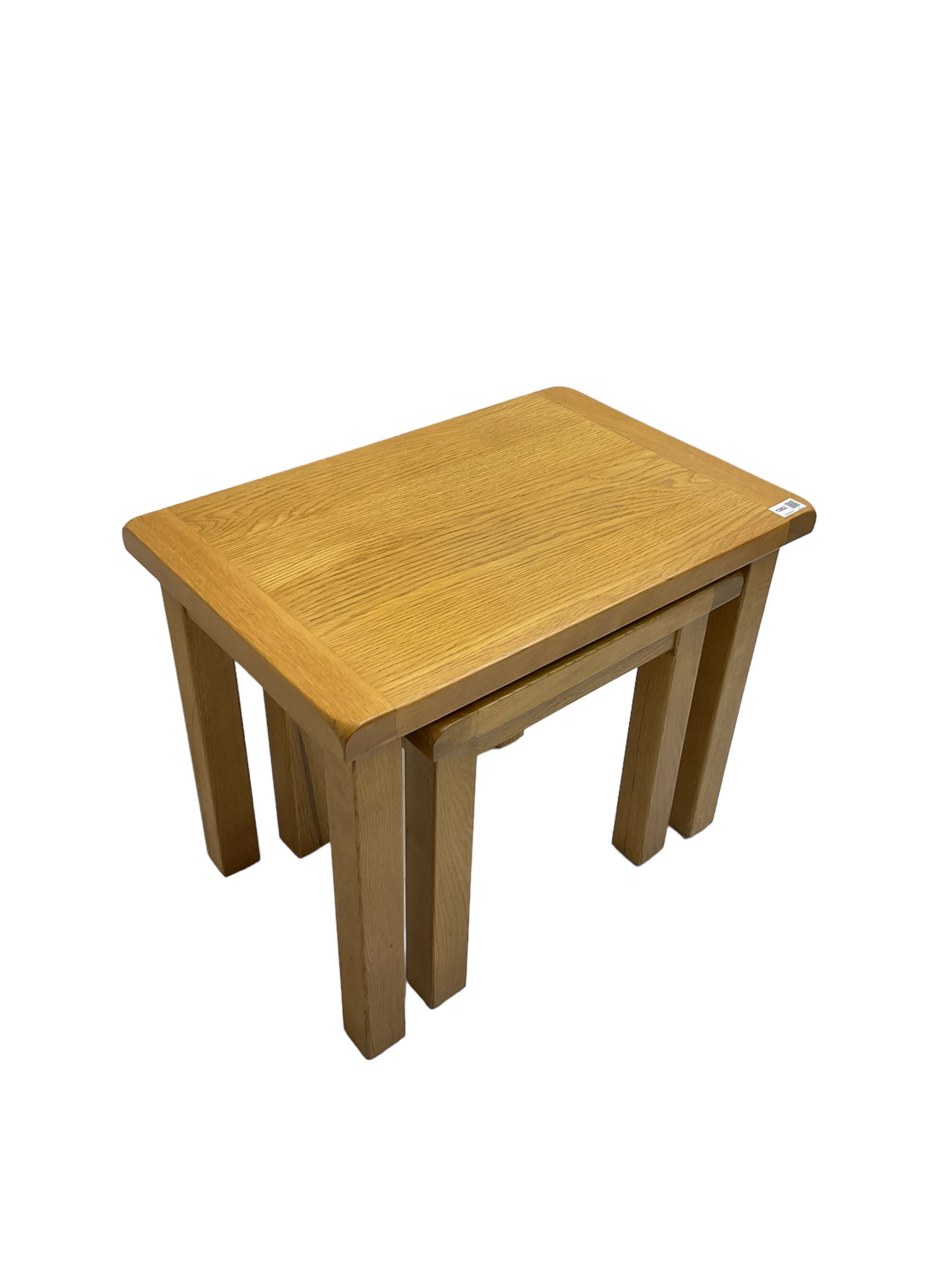 Light oak nest of two tables, rectangular top raised on square supports