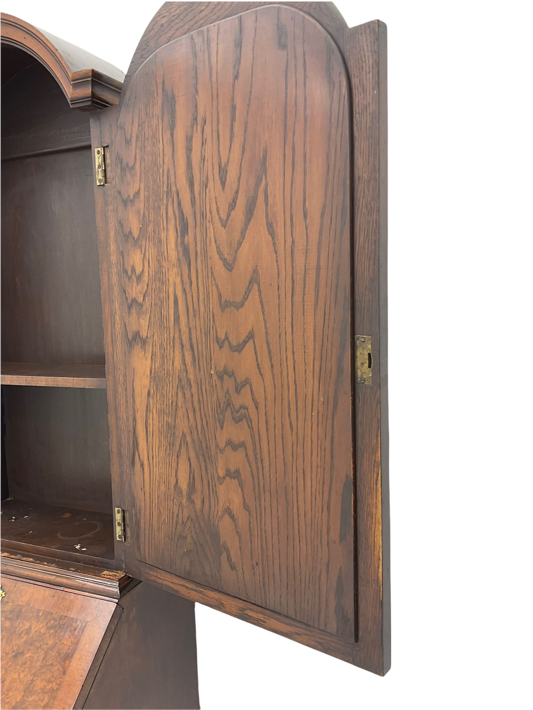 Small early 20th century Queen Anne style bookcase on bureau secretaire, the moulded arched pediment over mirrored door in shaped frame, the bureau fitted with fall front enclosing curved fitted interior, cushion moulded drawer over single drawer, on scroll and shell carved cabriole supports