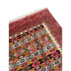 Persian red ground rug, the field divided into horizontal rows and decorated with geometric motifs, intricately pattern borders and end panels