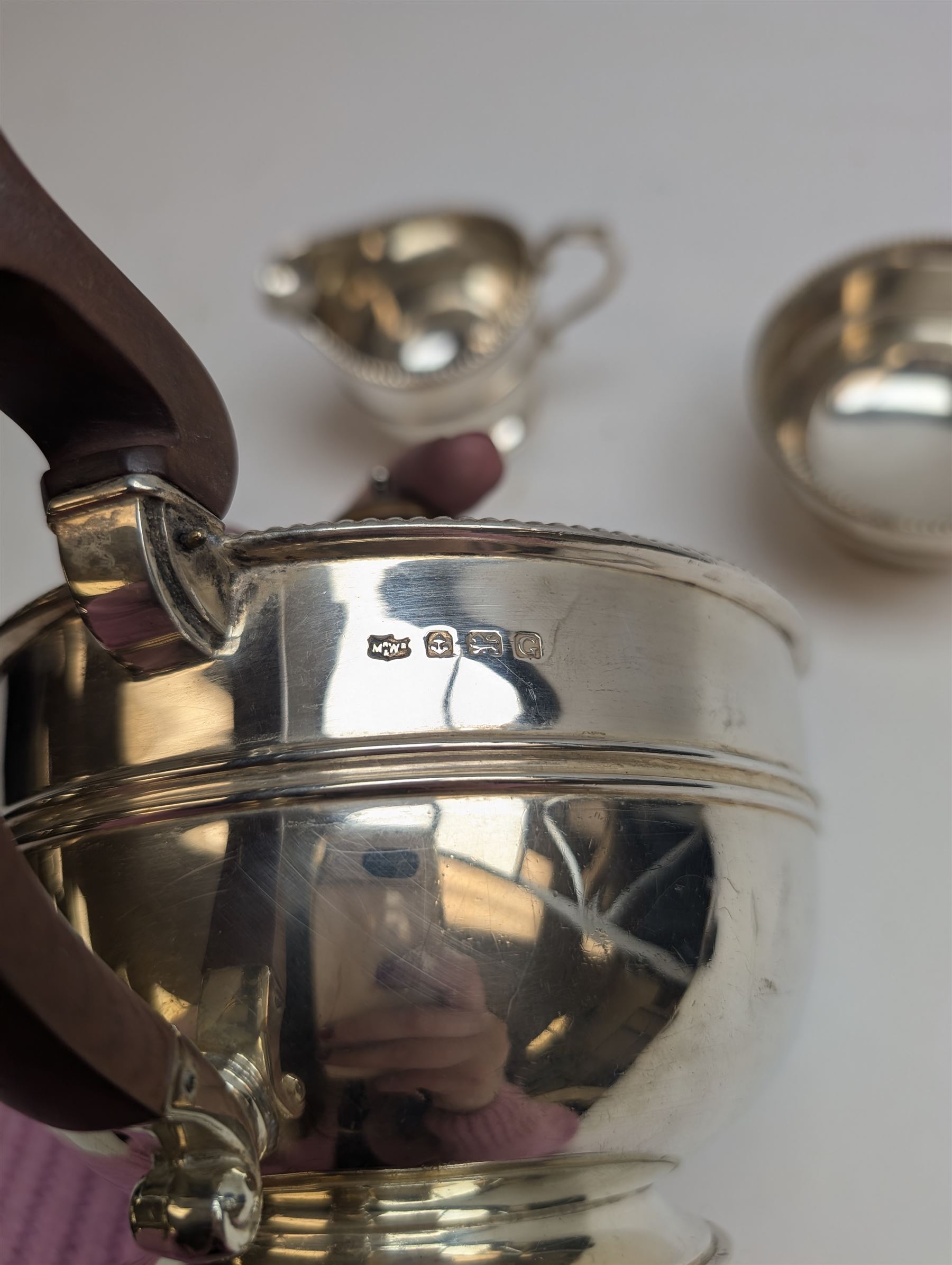 1930s silver three piece tea service, comprising teapot, milk jug and sugar bowl, each of circular form with oblique gadrooned rim, the teapot with Bakelite handle and finial, hallmarked Mappin & Webb Ltd, Birmingham 1931, teapot H14.5cm