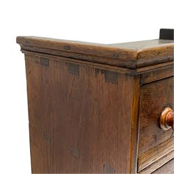 19th century oak spice rack, with moulded cornice over nine small drawers, each with turned handles, H43cm W45cm D25cm