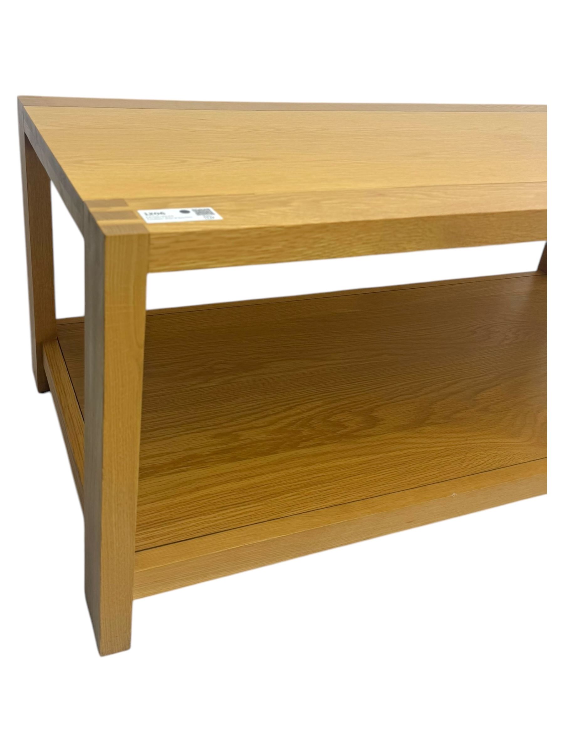 Light oak rectangular coffee table, with exposed finger joints to the corners, raised above a full-length undertier on straight supports