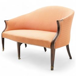 George III Hepplewhite design settee, arched back over serpentine set, upholstered in salmon fabric with repeating pattern, on square tapering supports with brass cups and castors 