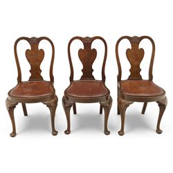 Queen Anne design walnut dining suite, comprising a rectangular dining table with carved moulded edge and rounded corners, raised on cabriole legs terminating in pad feet, together with a set of six matching dining chairs, each with shaped splat back, leather upholstered seat and cabriole supports (Extends to 230cm)