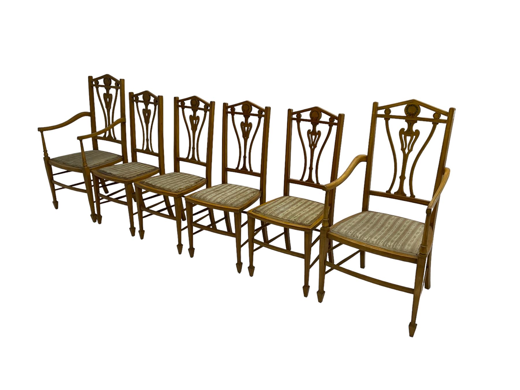 Set six (4+2) Edwardian satinwood dining chairs, triangular cresting rail painted with laurel wreath, shaped and pierced splat flanked by two shaped upright rails, with boxwood stringing, upholstered seats, on square tapering front supports with spade feet